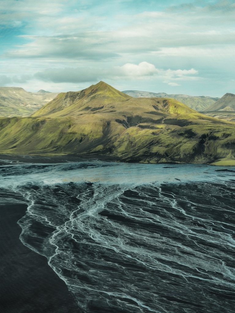Green mountains overlook braided river delta